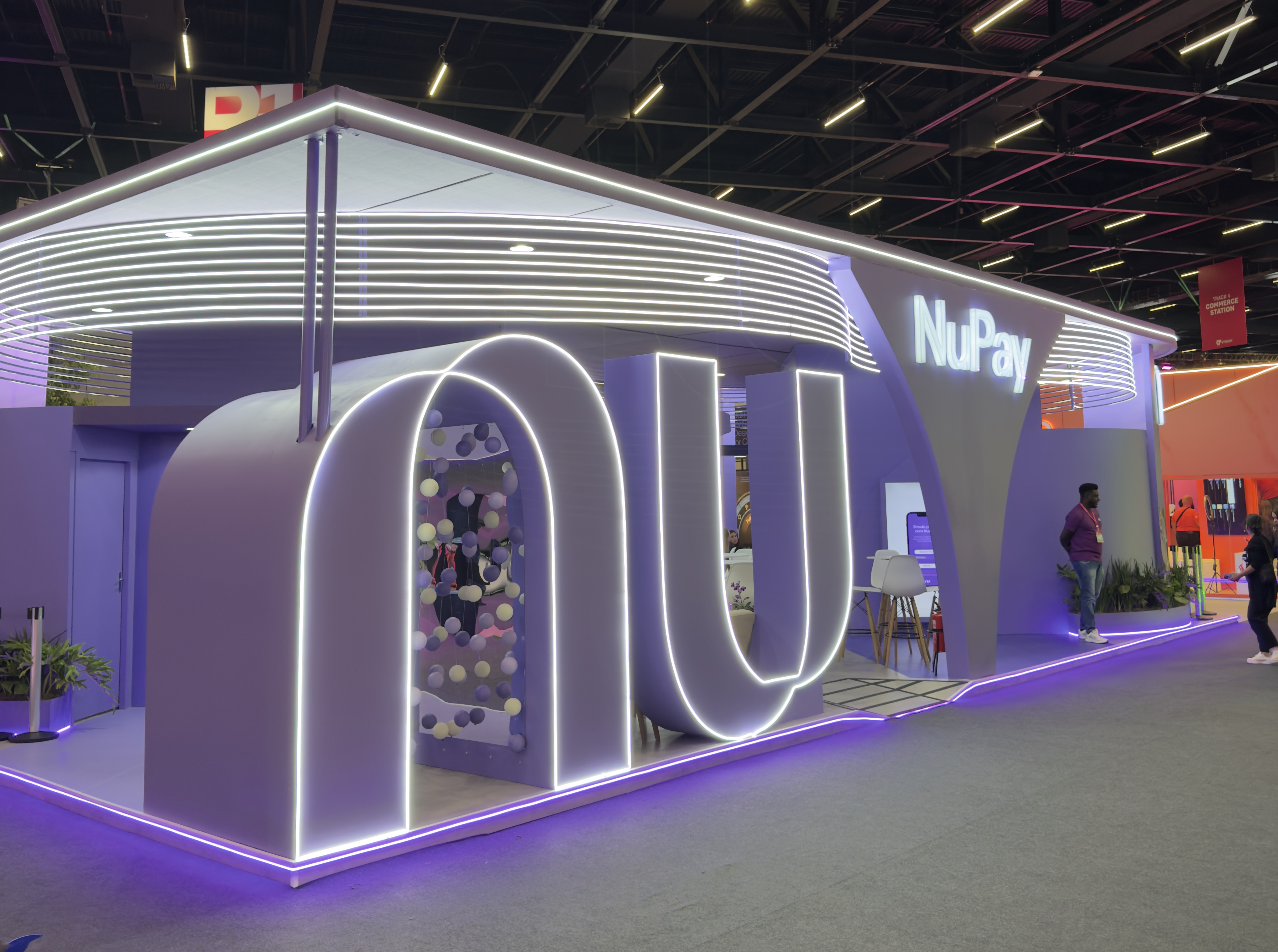 Stand NuPay no VTEX Day — estrutura iluminada em São Paulo